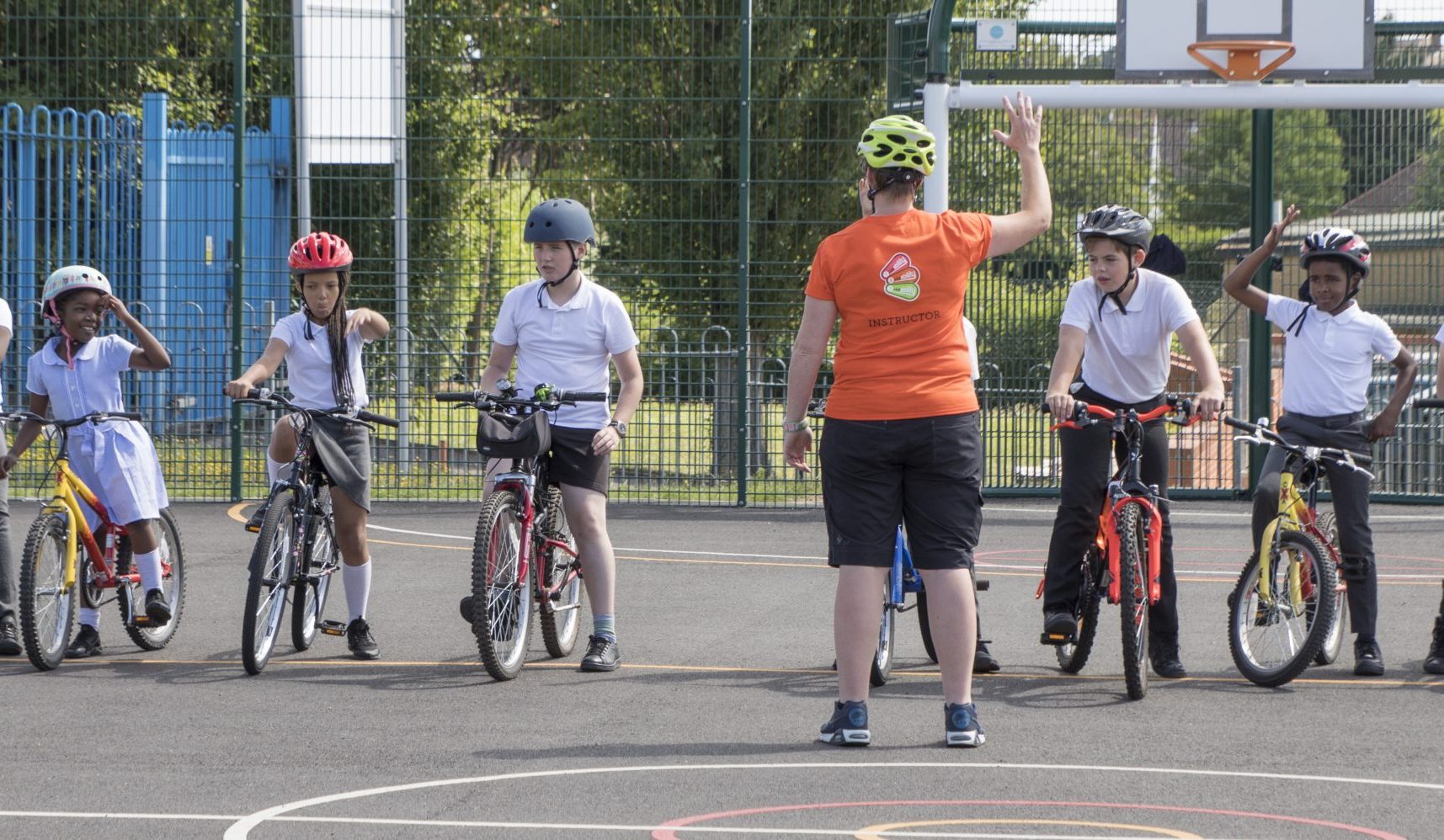 An instructor in front of a line of children on bikes