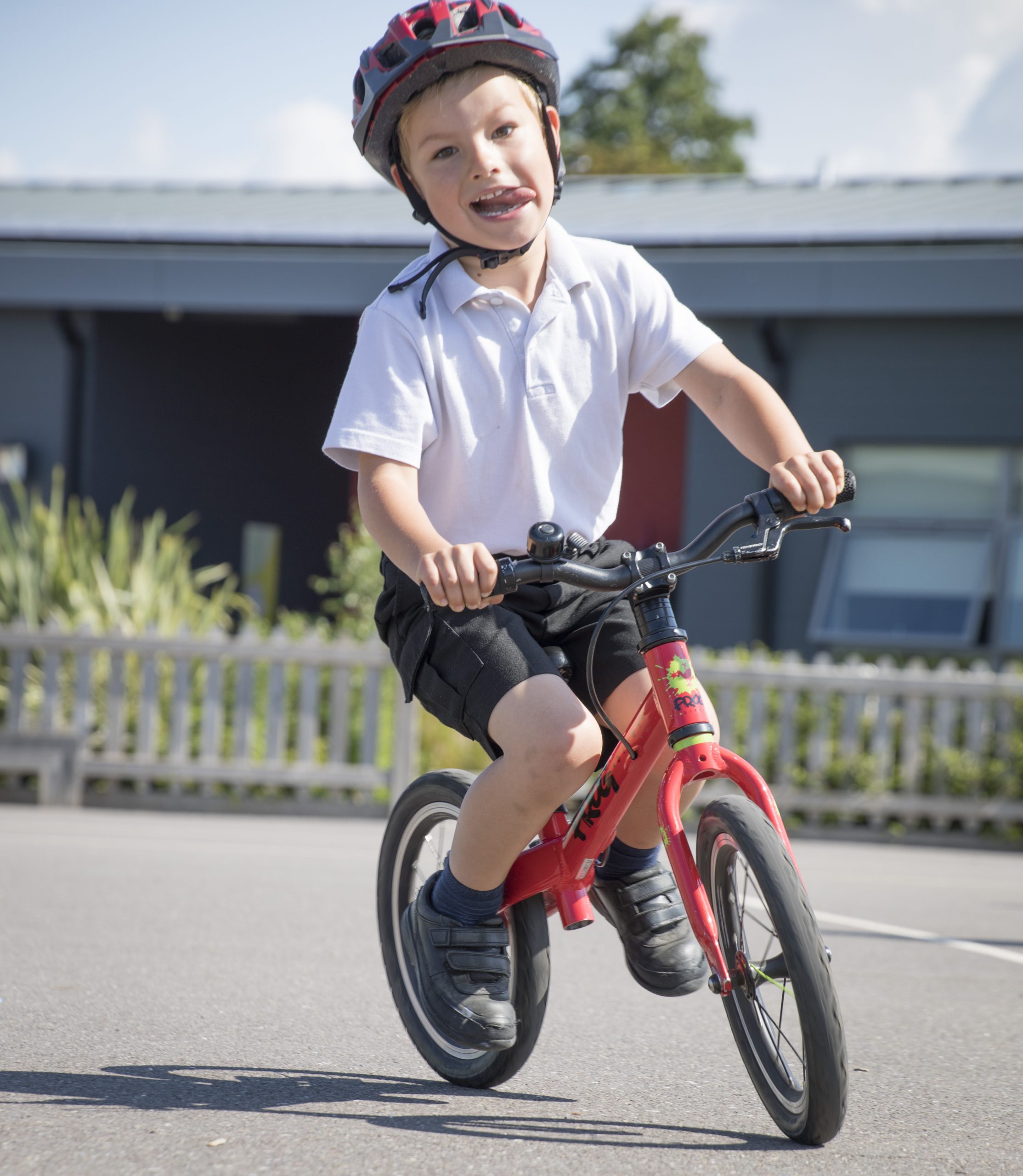 Small boy on a bike sticking his tongue out