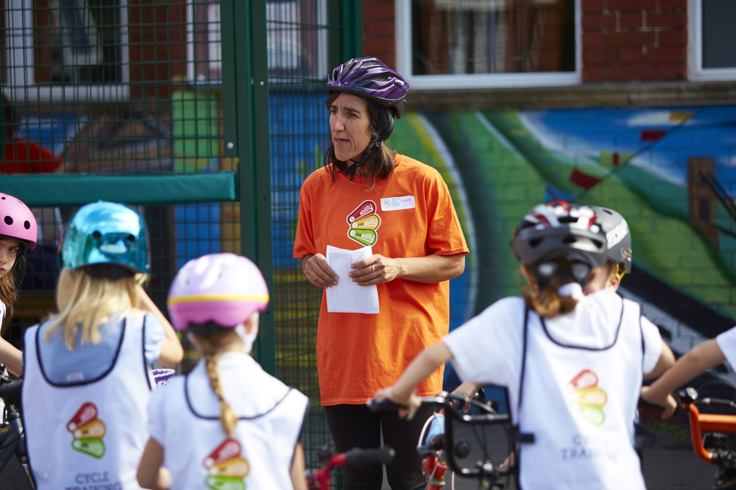 A bikeability instructor surrounded by four students on their bikes