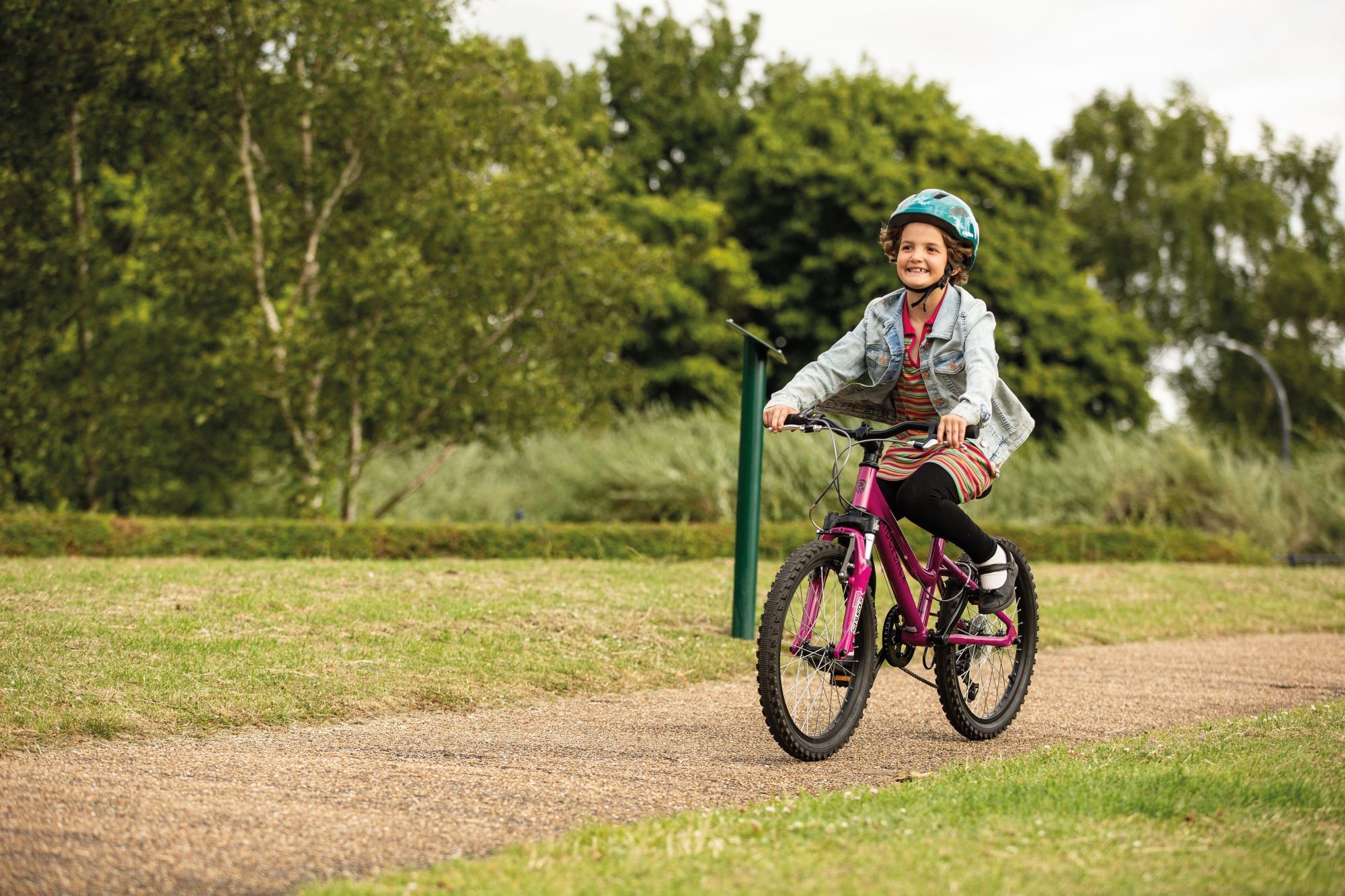 A young girl cycling through a park
