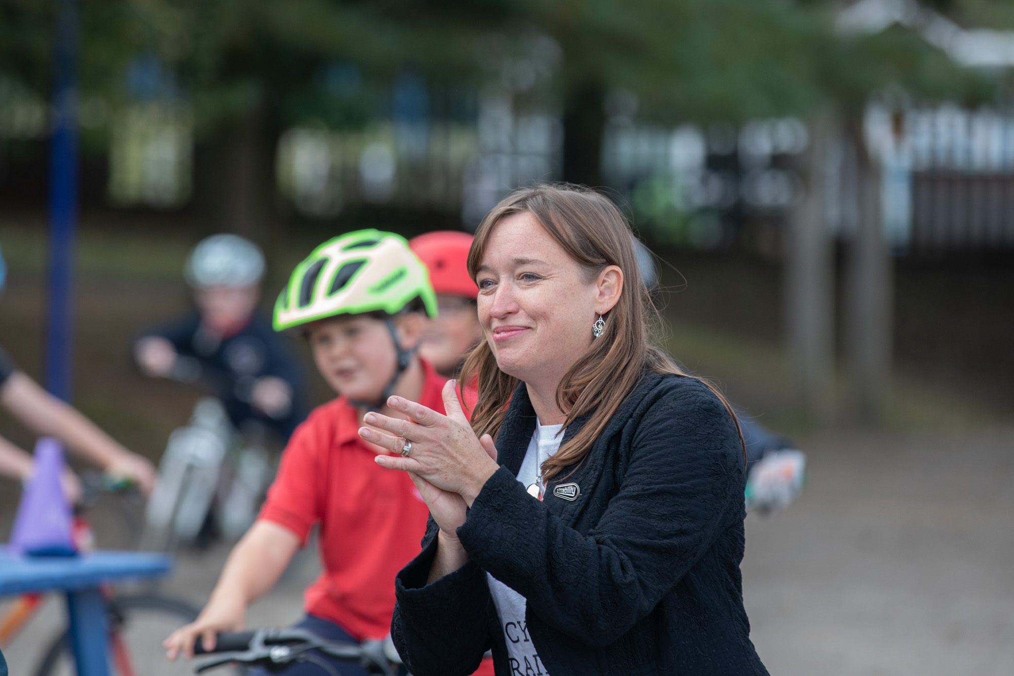 Emily Cherry applauding cyclists in playground
