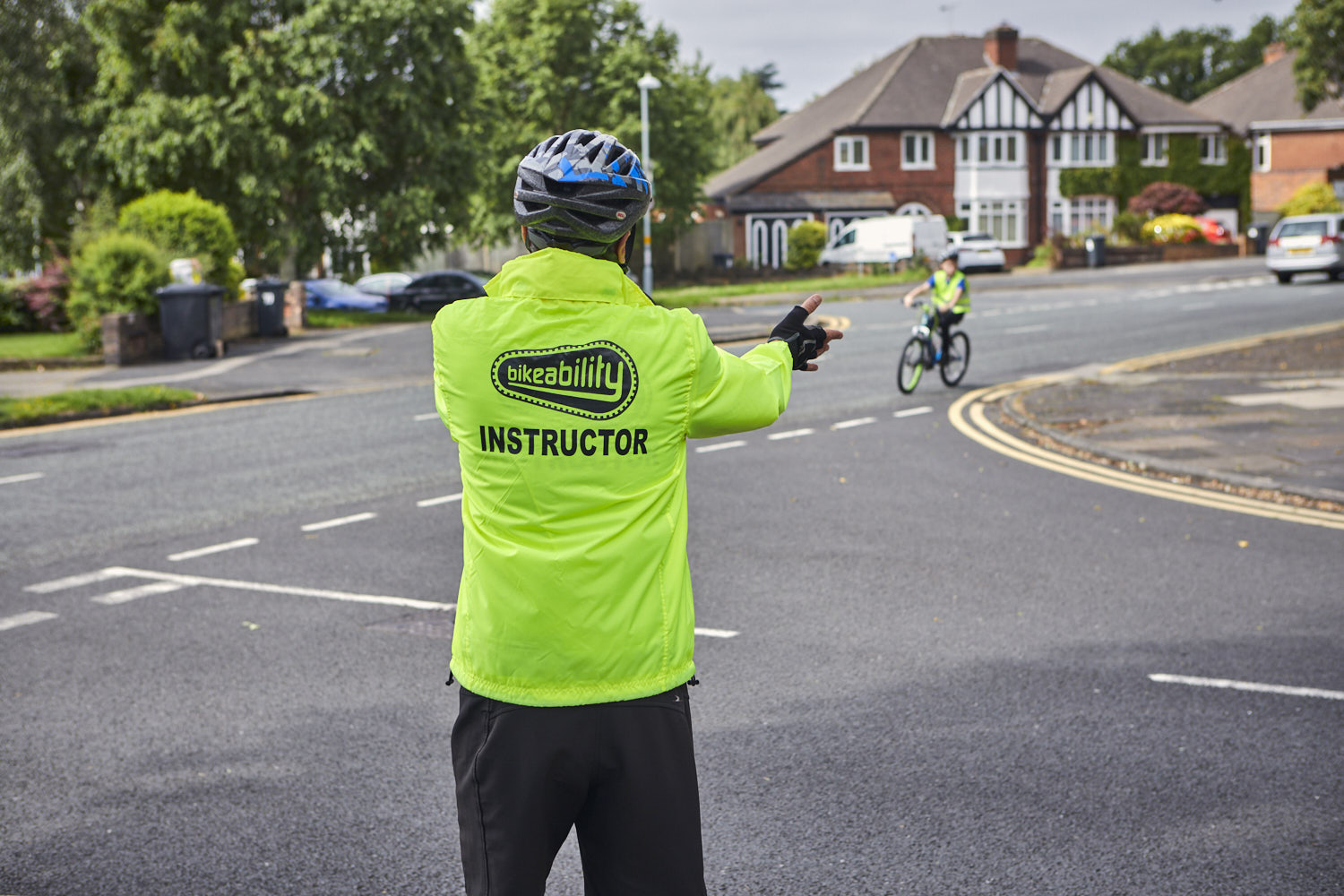 Bikeability instructor teaching a child at a road junction