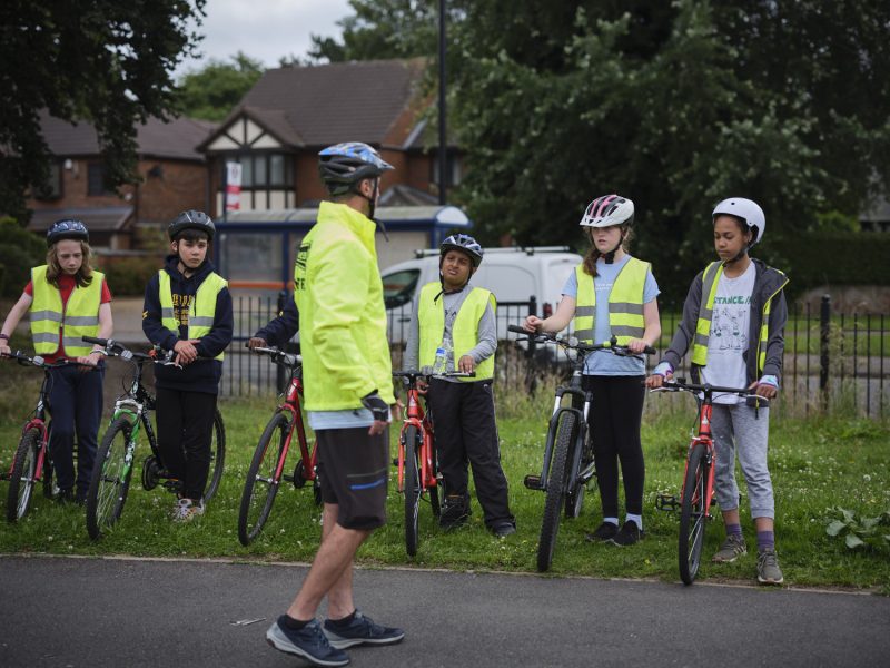 An instructor with a group of children learning Bikeability