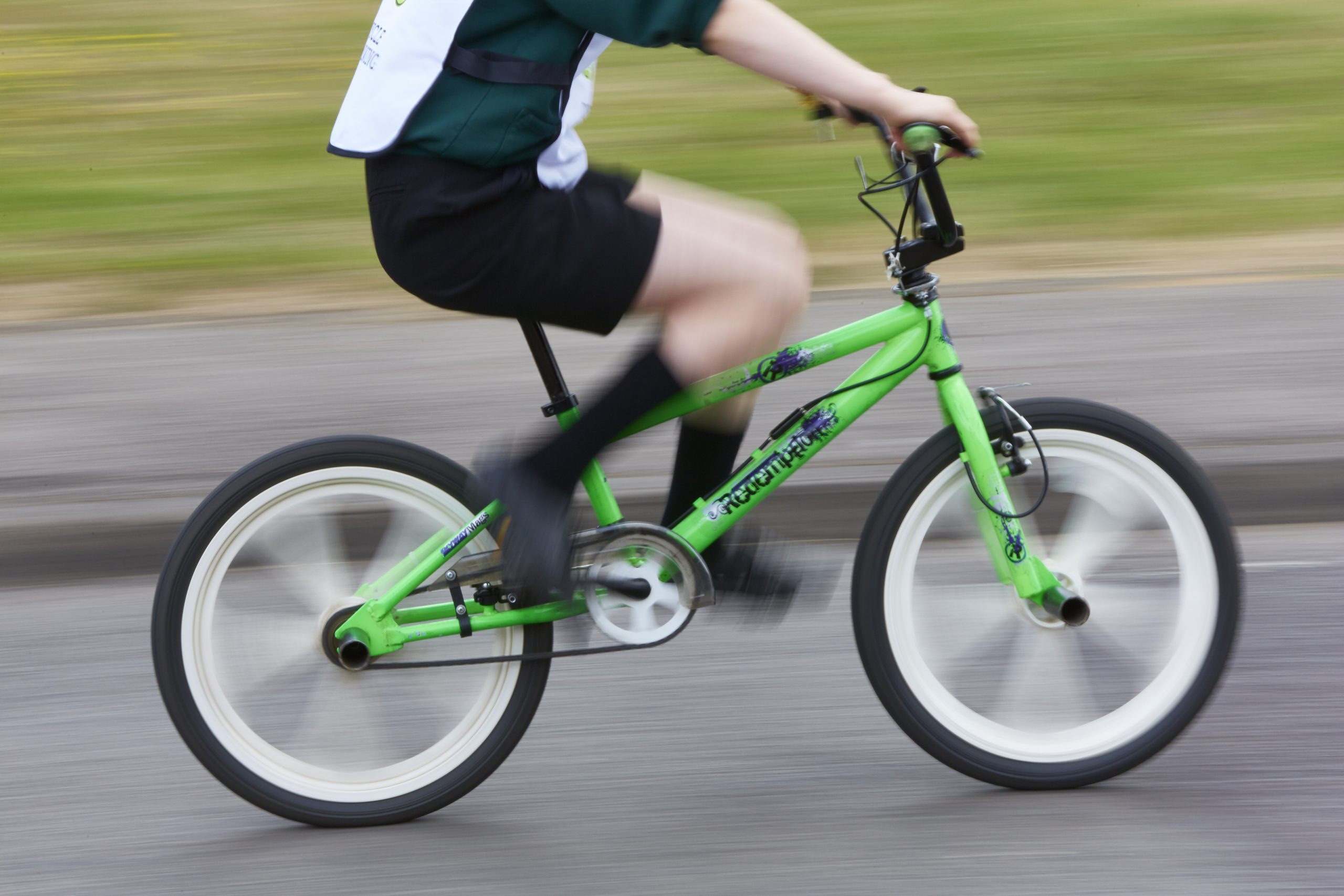 A image of a child riding a bike which is cut off from the shoulders.