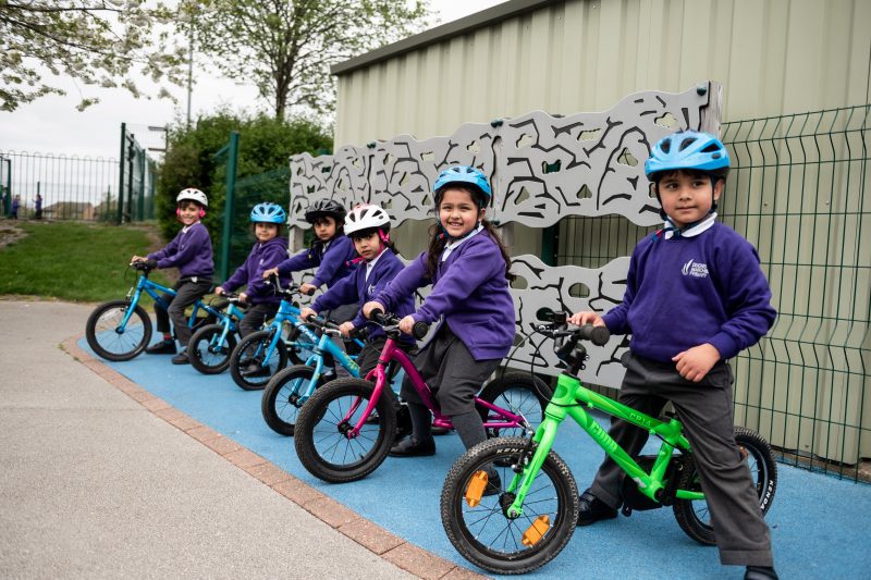 a group of children with balance bikes