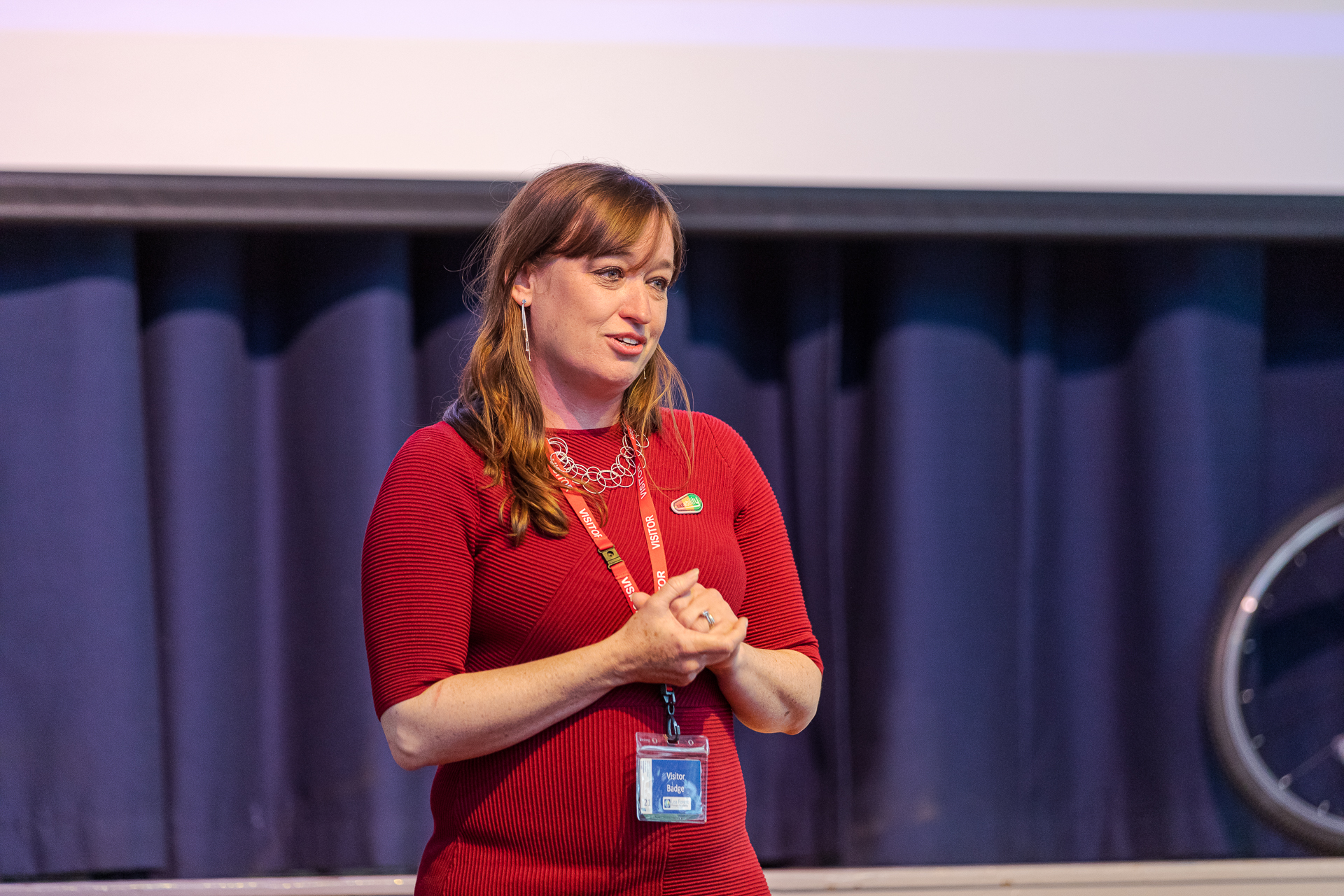 Bikeability CEO Emily Cherry wears a red dress as she gives a speech