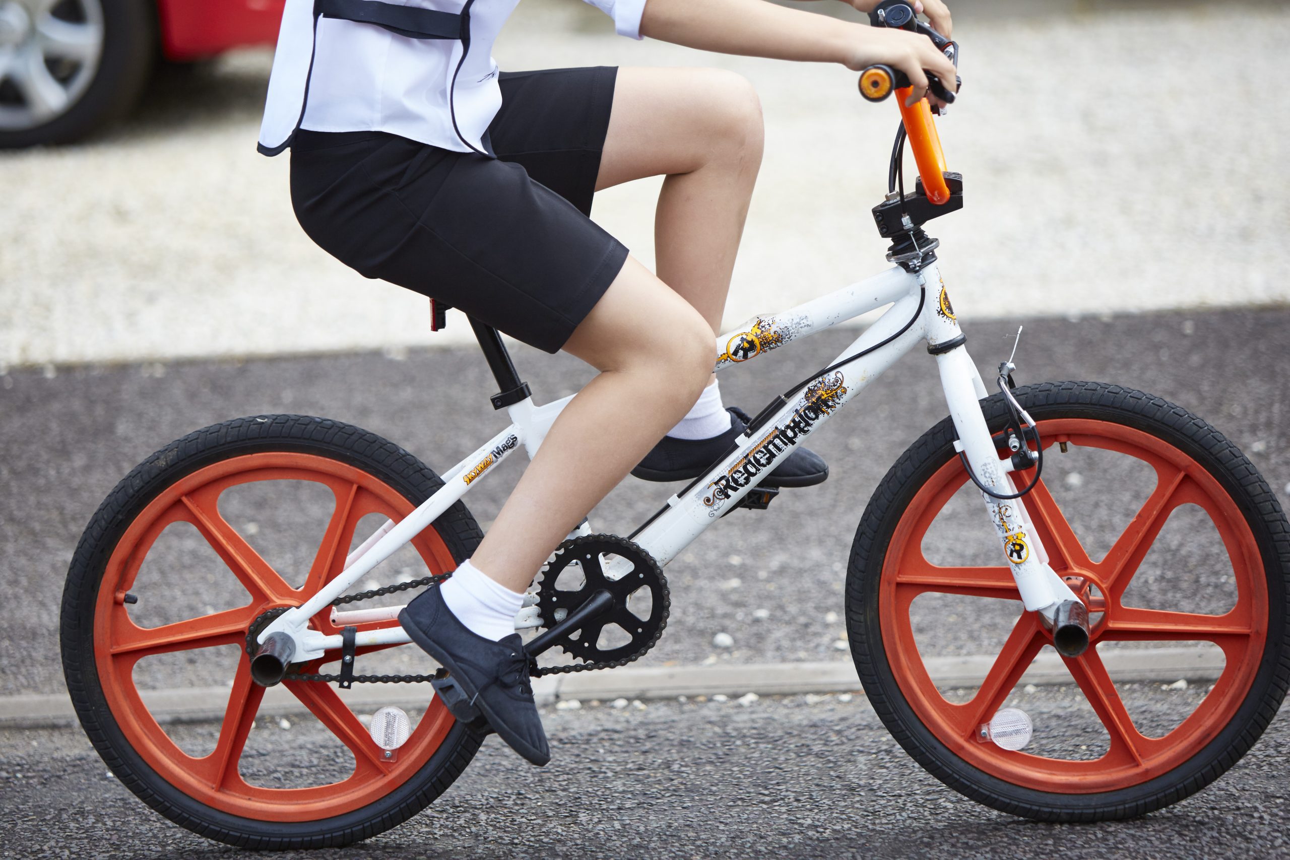 A close up image of a child riding a cycle, the image is focused on the frame of the cycle.