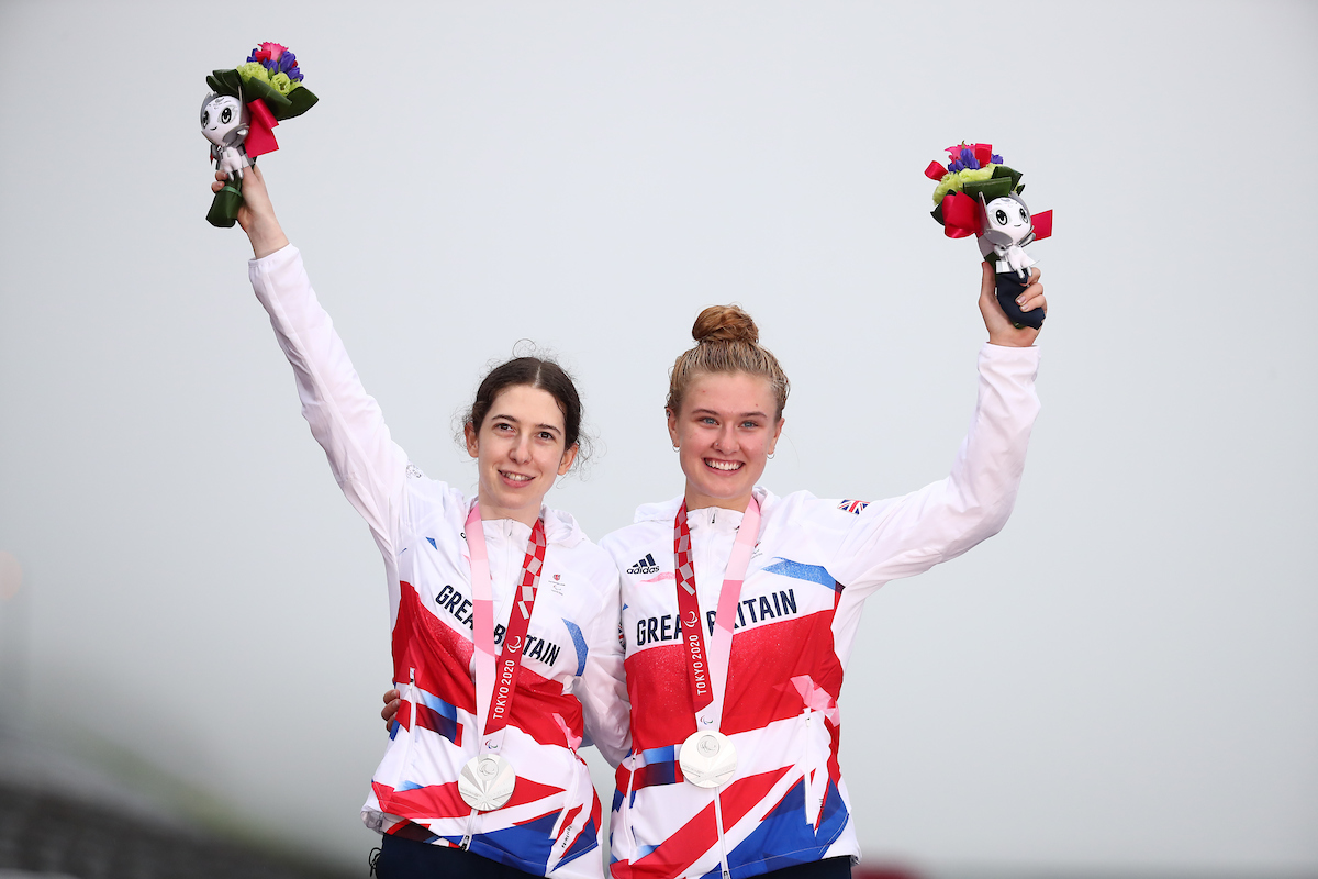 Sophie Unwin and pilot Jenny Holl celebrate on the podium after winning a silver medal in the Women's B Road Race at the Tokyo 2020 Paralympics