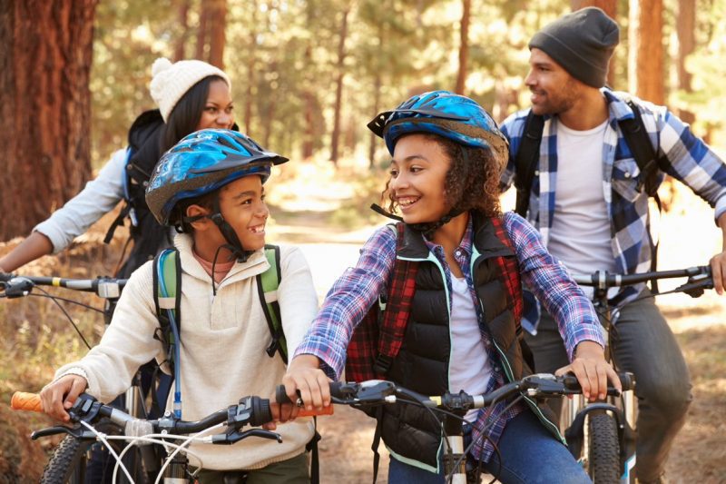 Family cycling in woods