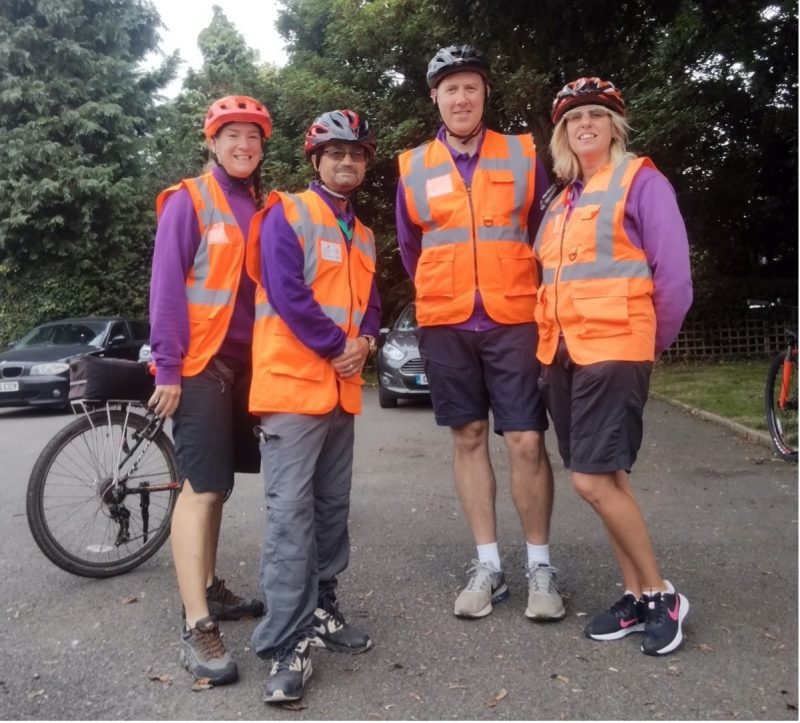 Four Bikeability instructors smiling in front of their bikes