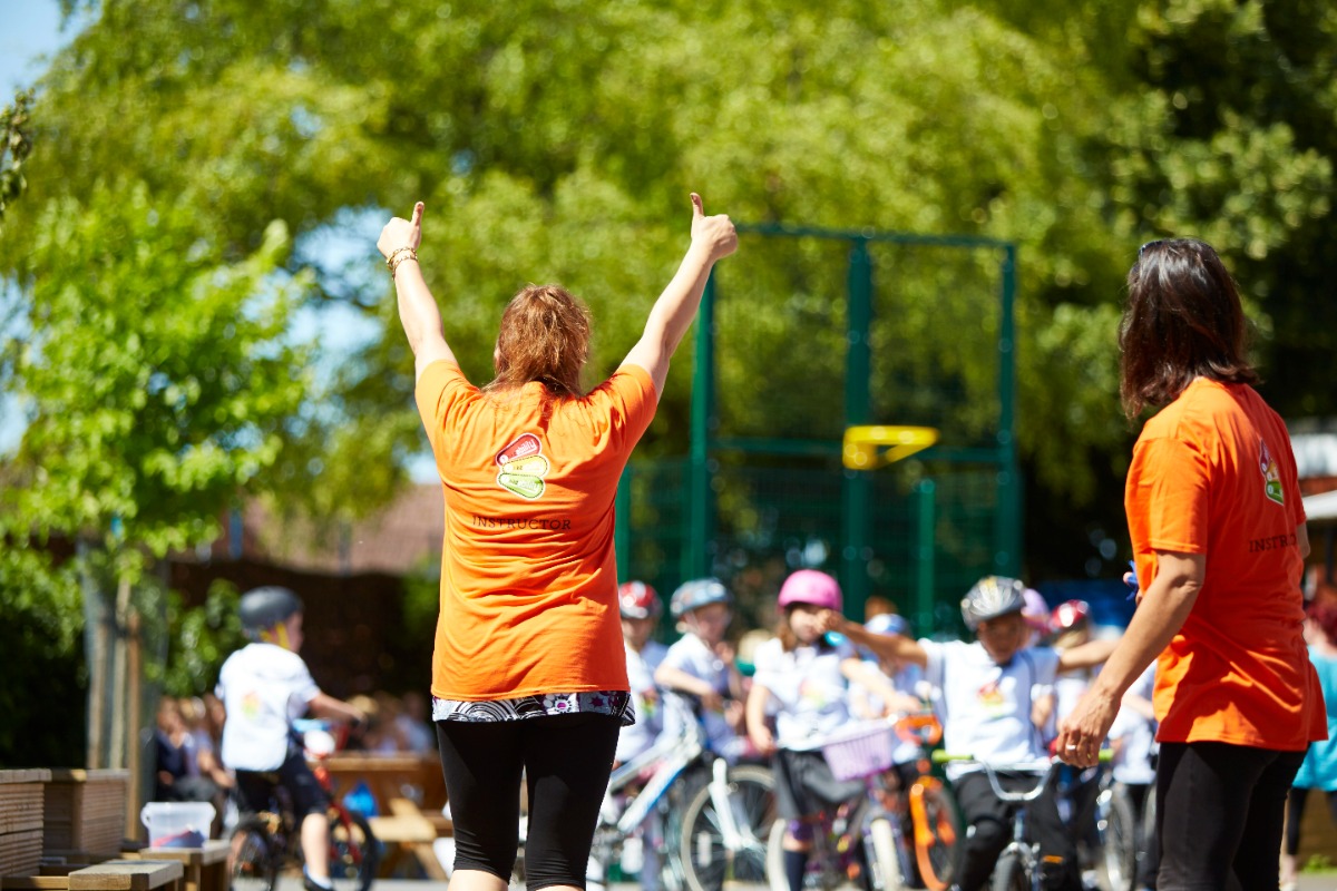 A Bikeability instructors gives her trainees a big thumbs up
