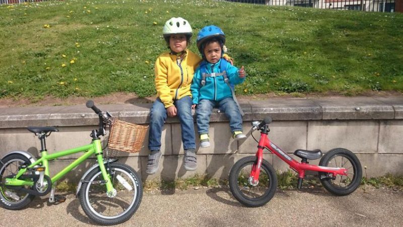 Two young children with their bikes smiling
