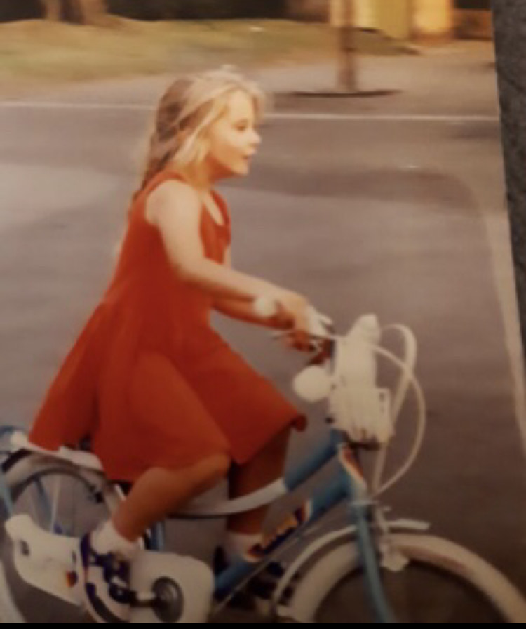 Emily as a young child on her bicycle