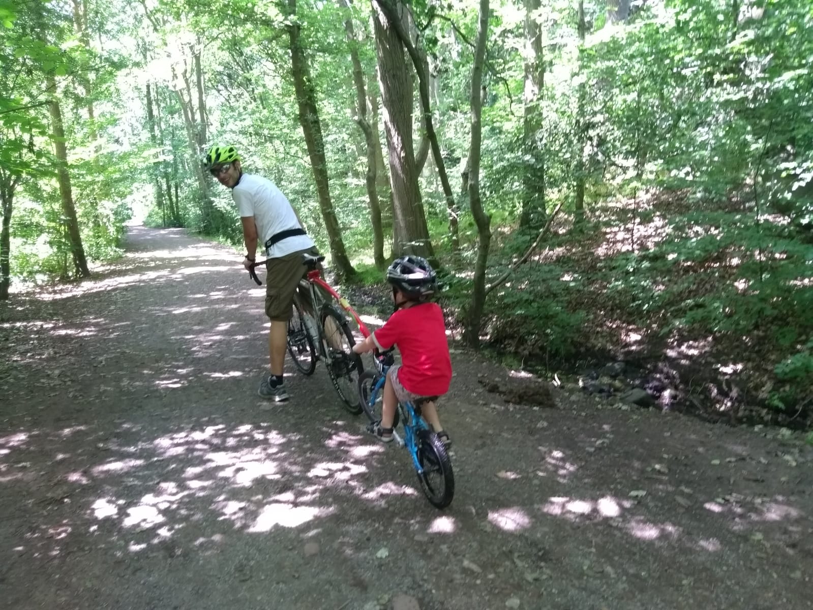 Family cycling together using a follow me tandem