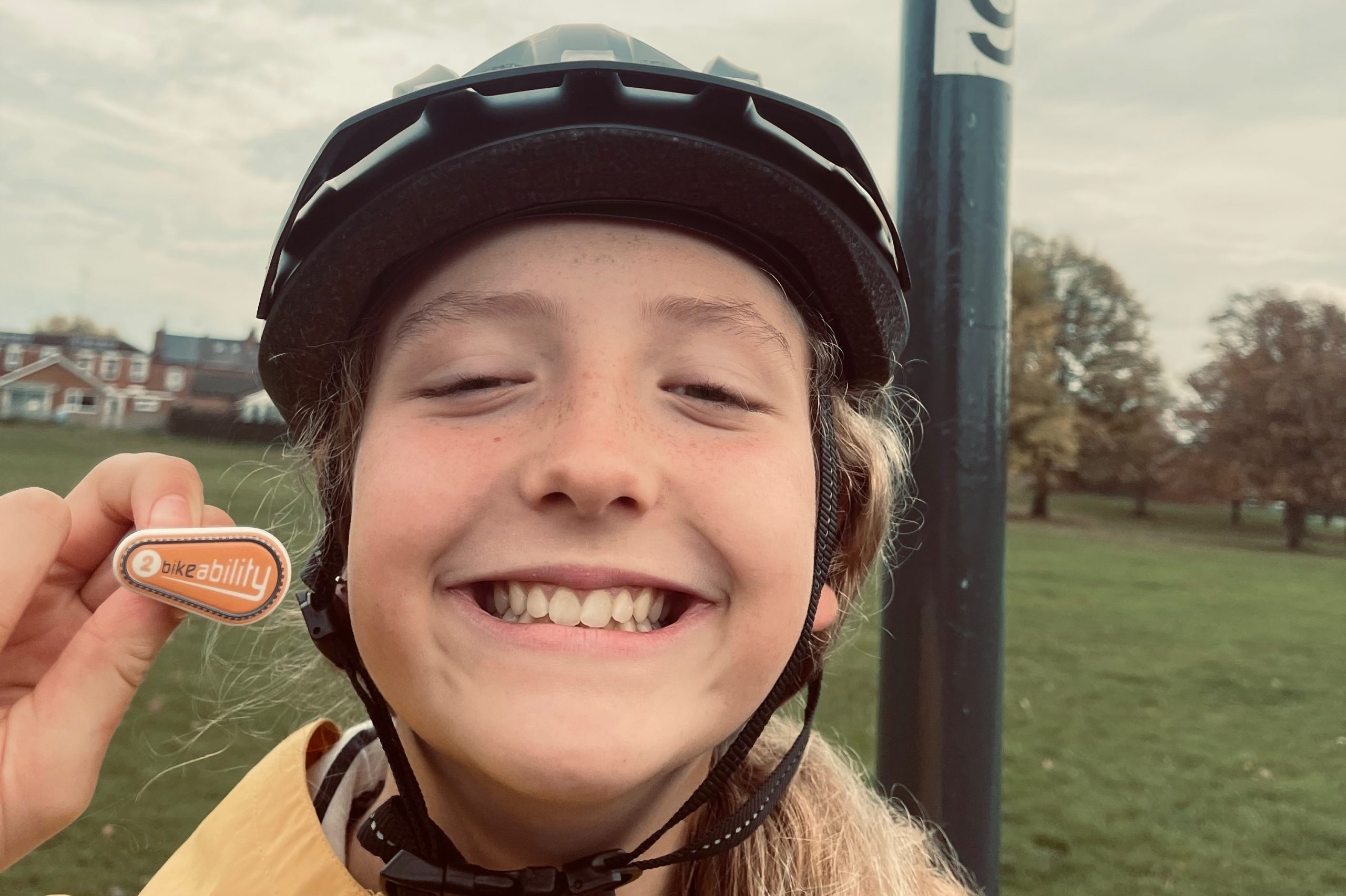 Lilly smiling with her Bikeability badge