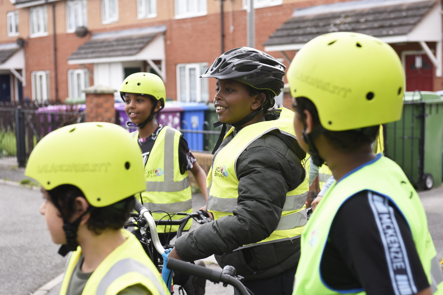 Four Bikeability students in high vis and helmets