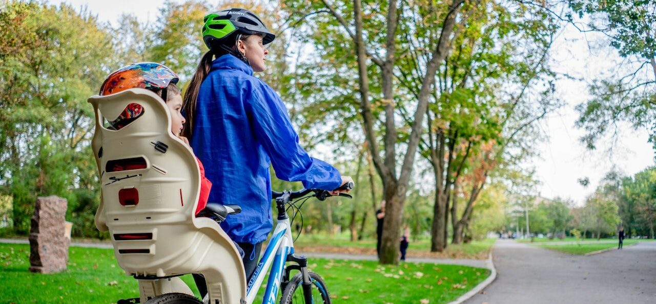 A mother cycling with her child in a bike seat