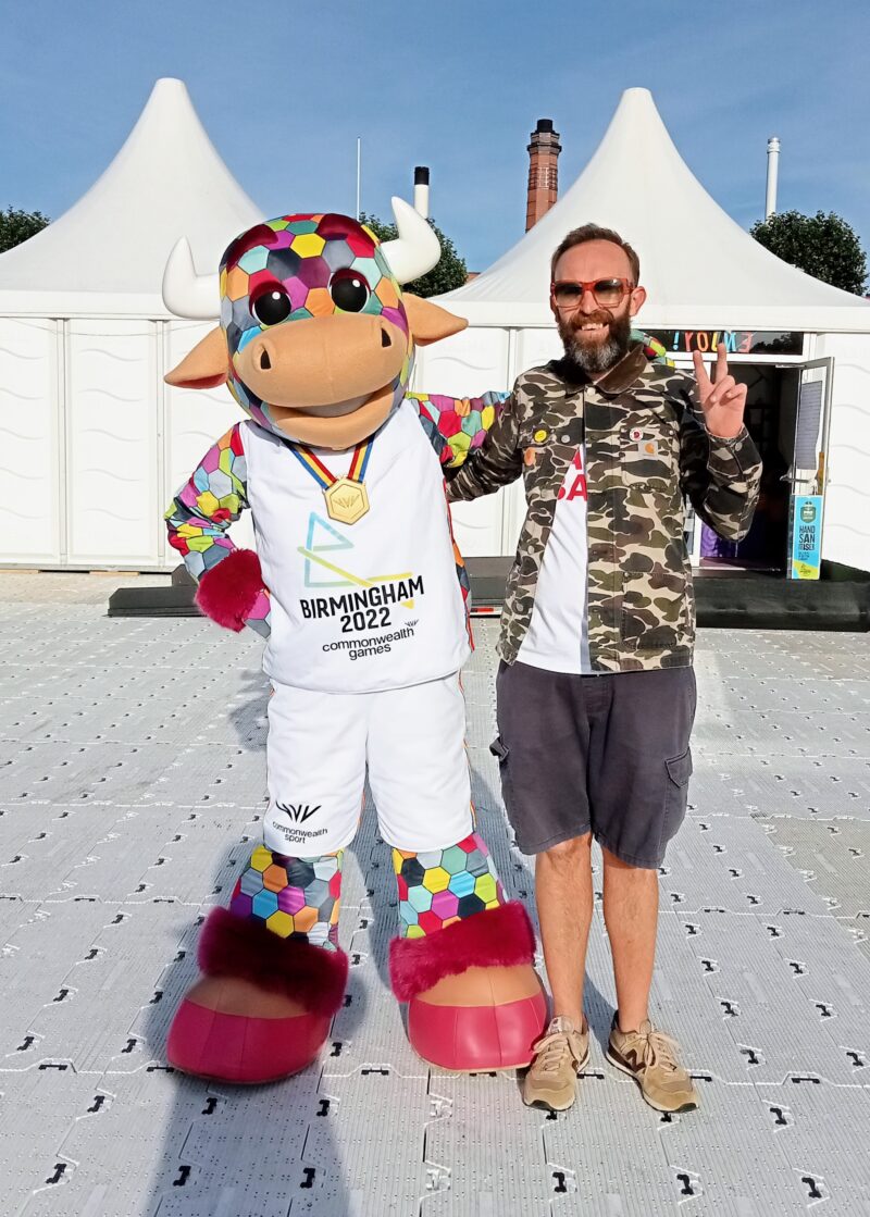 Perry with the Commonwealth Games Bull waving and smiling