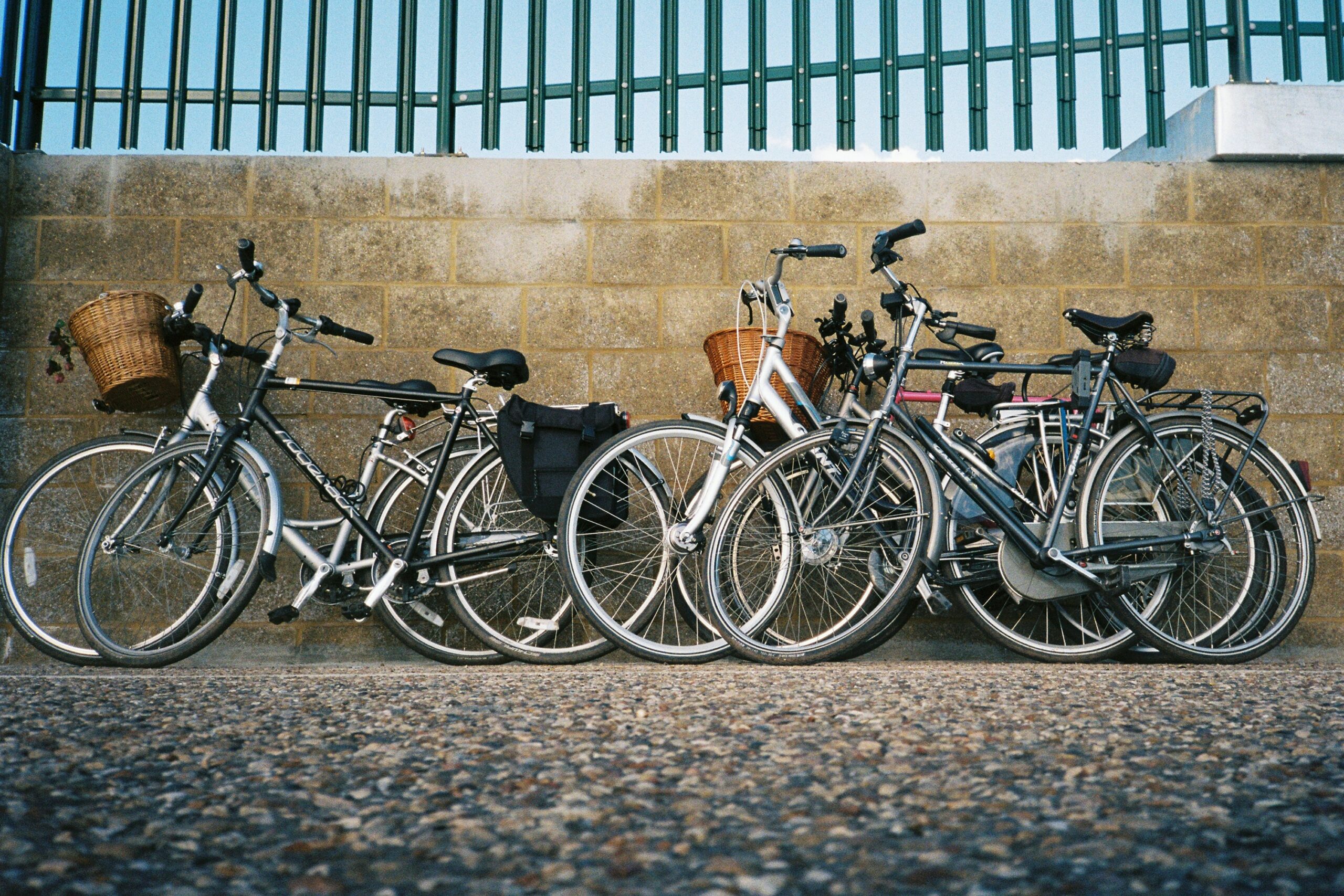 Six bicycles leaning up against a wall