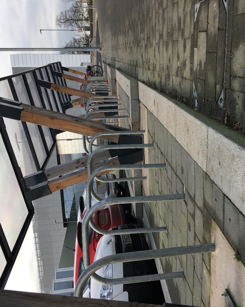 A group of inaccessible metal cycle racks in a car park.