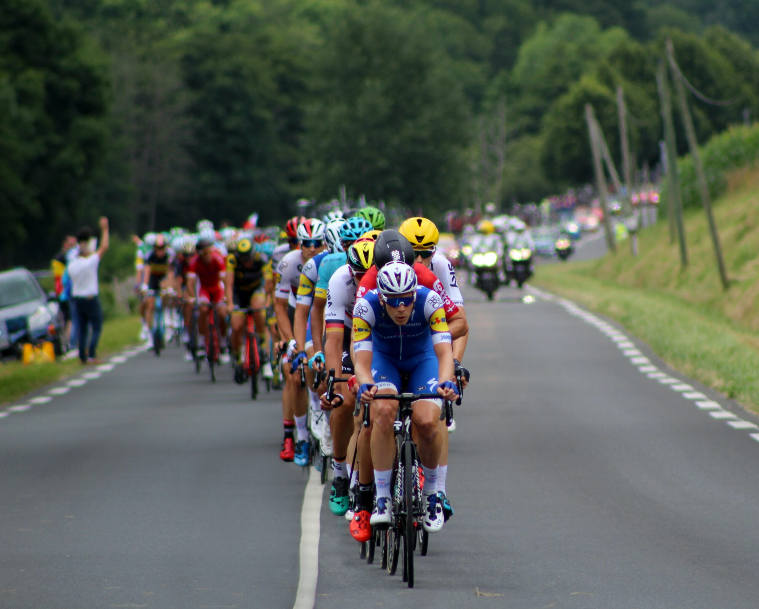 A group of cyclists taking place in a road race in the countryside
