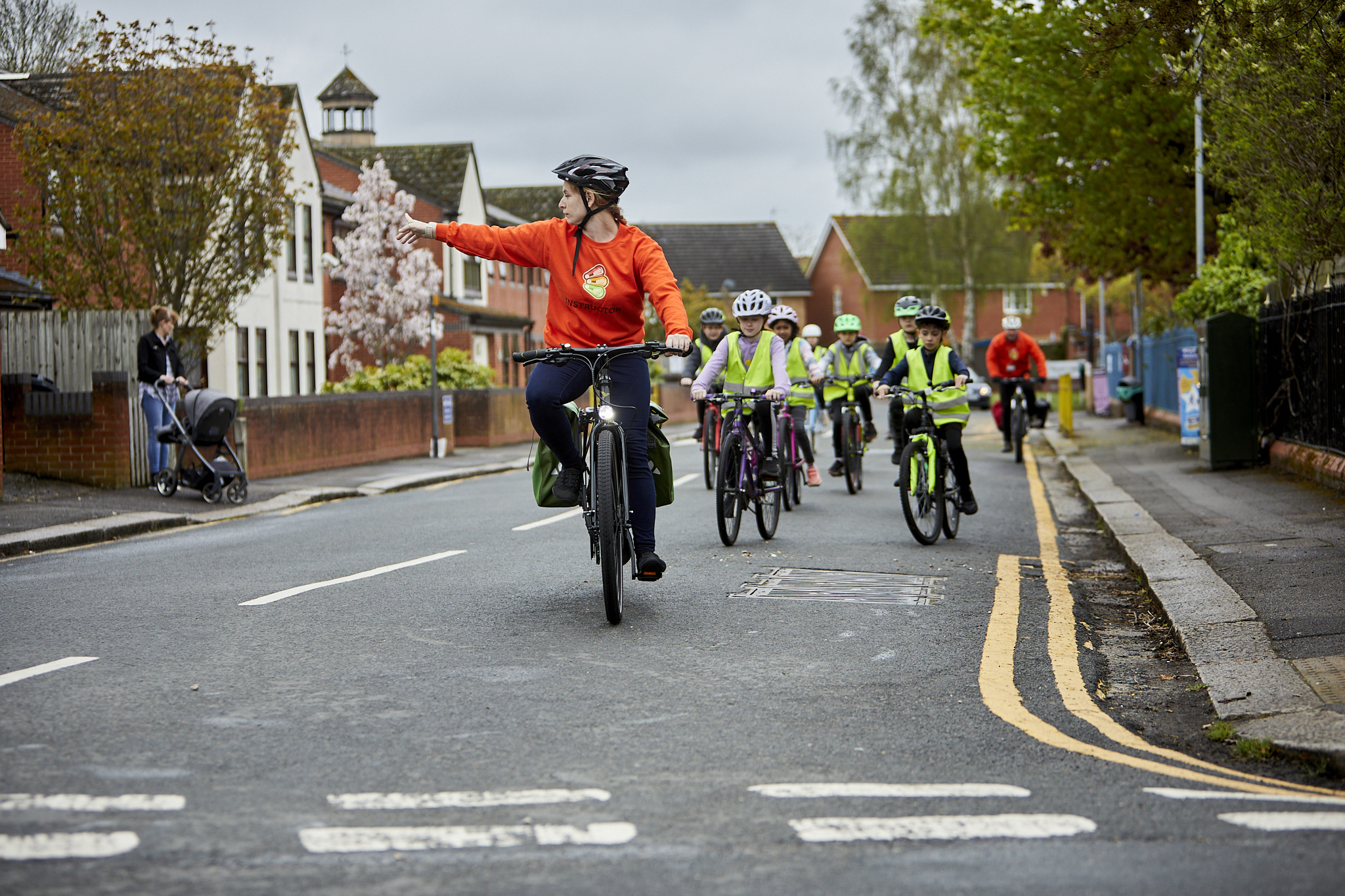 A group of children cycling, with a rider in the middle in focus, smiling