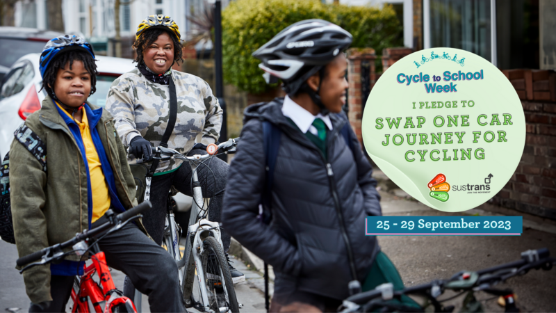 A family of three on their cycles. There is a sticker on top that says I pledge to swap one car journey for cycling