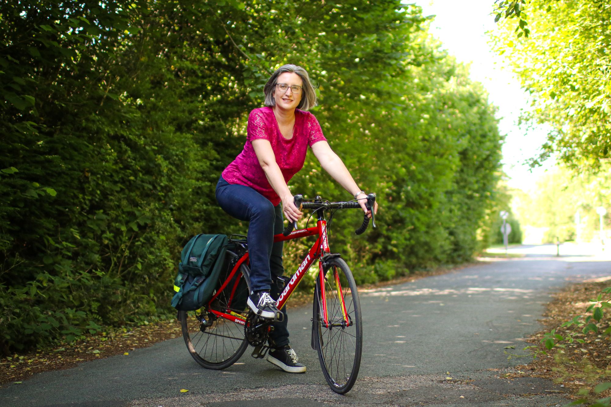 Karen Gee from Cycle Sprog. She is sitting on a bicycle on a country lane.