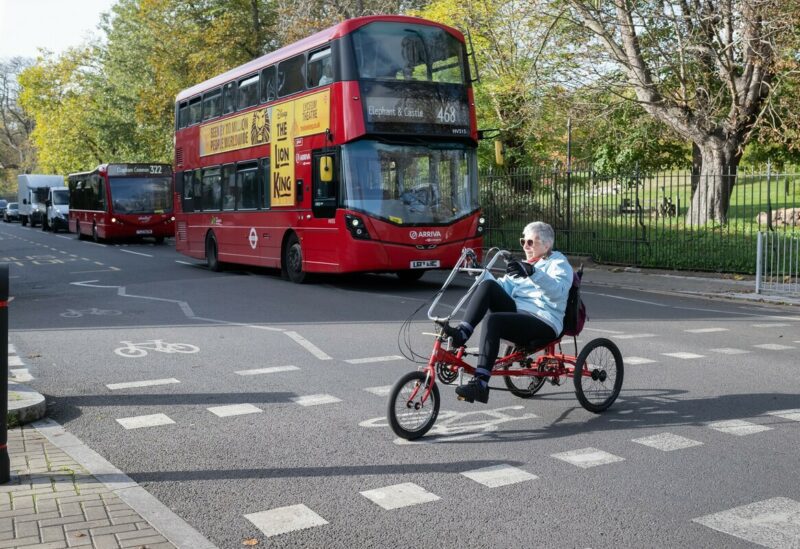 A cyclist on a tricycle crossing the road to rejoin a cycle path