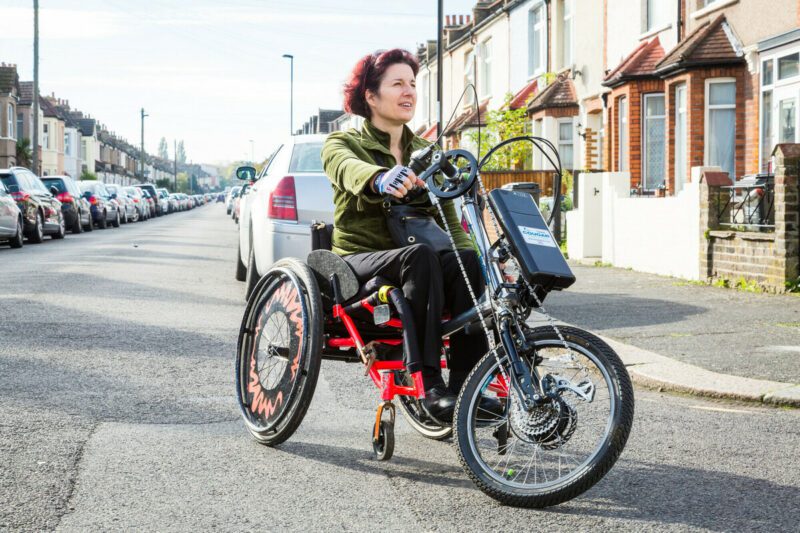 A woman riding a hand-tricycle