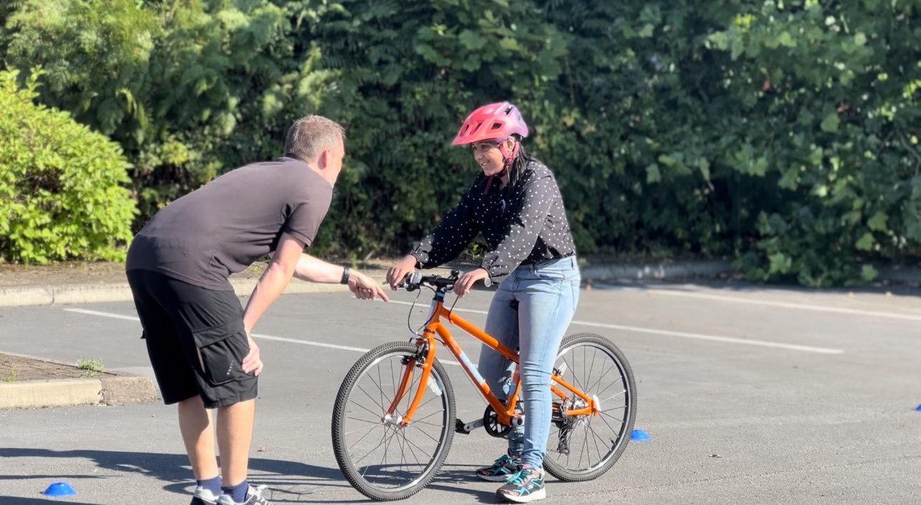 A Bikeability instructor gives a rider some tips during their lesson at a Decathlon store