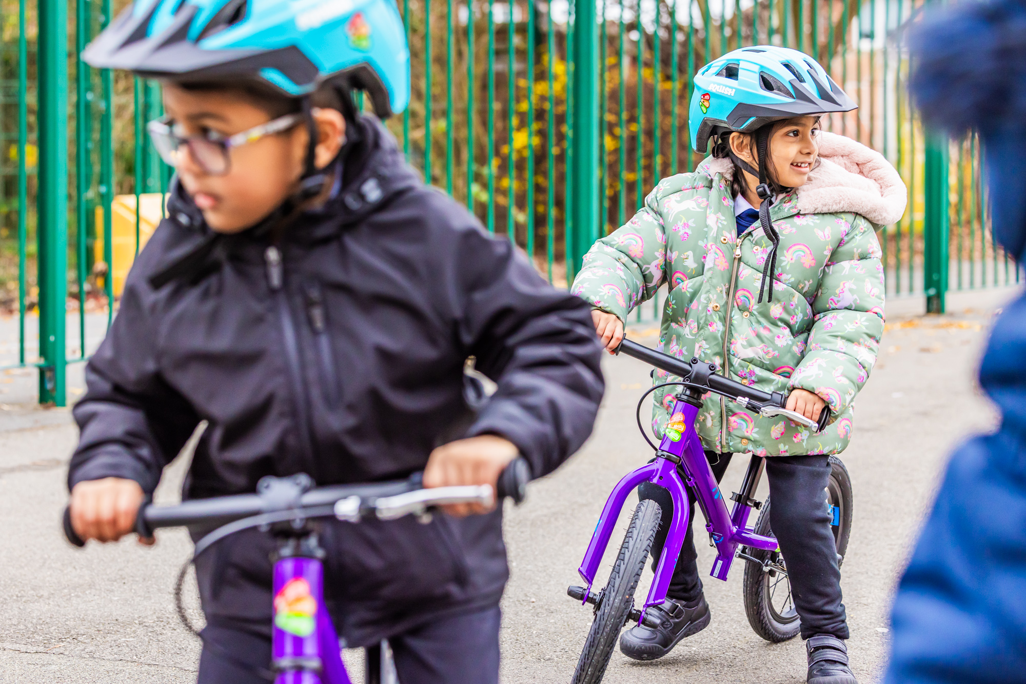 Children on balance bikes wearing helmets